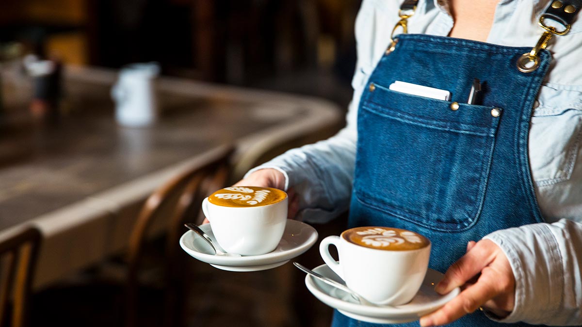 A waiter carrying two coffees at St Ali Cafe in Melbourne.