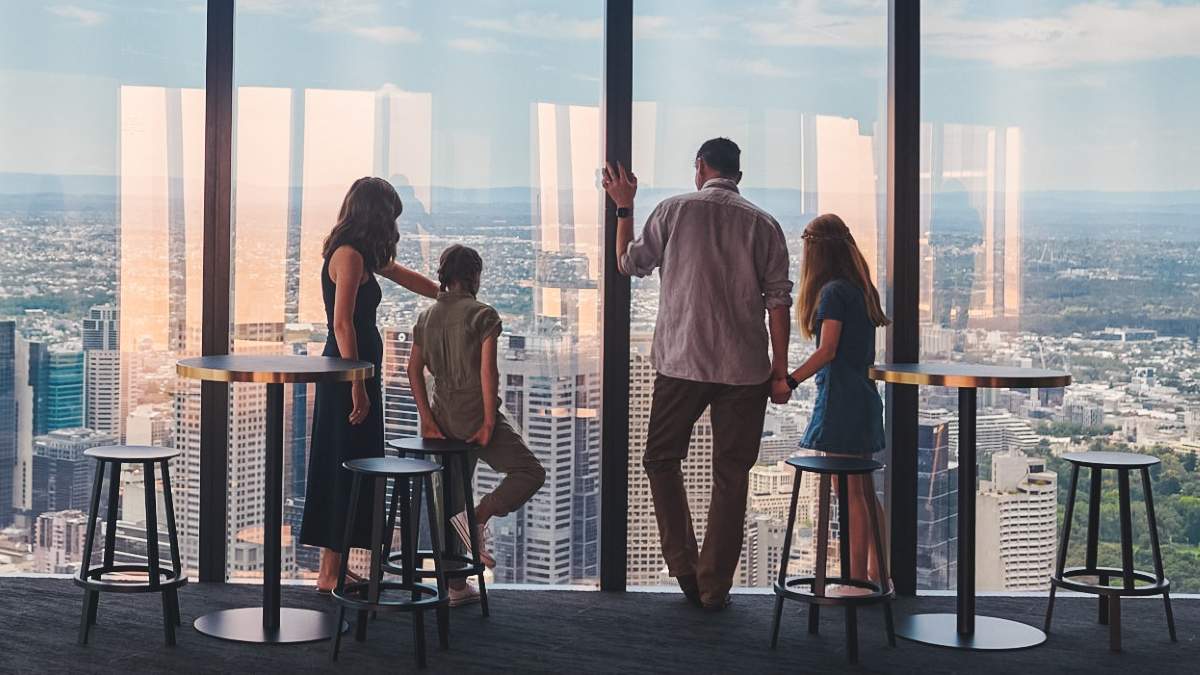 family of four looking out of Melbourne Skydeck at the views