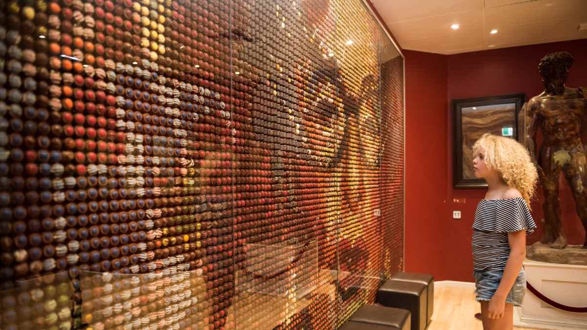 girl looking at a chocolate wall forming art