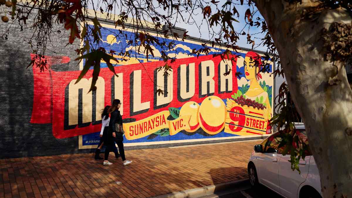 two women walking past the Mildura Sunraysia mural
