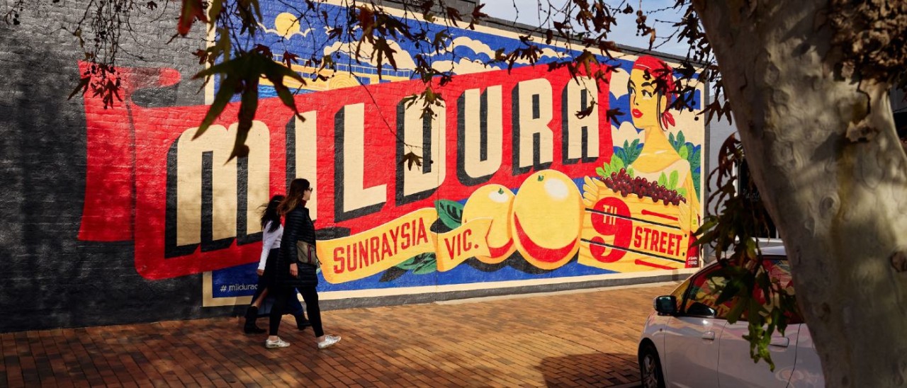 two women walking past the Mildura Sunraysia mural