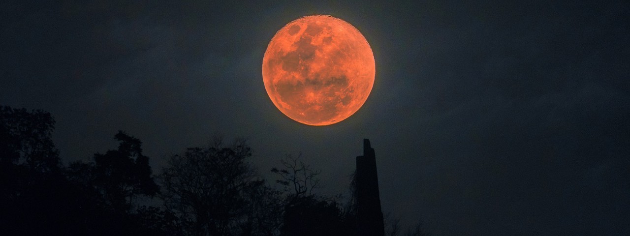Red blood moon with an iridescent reddish hue in the night sky