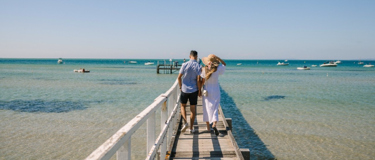 A couple enjoying a stroll along Sorrento Pier on a sunny afternoon