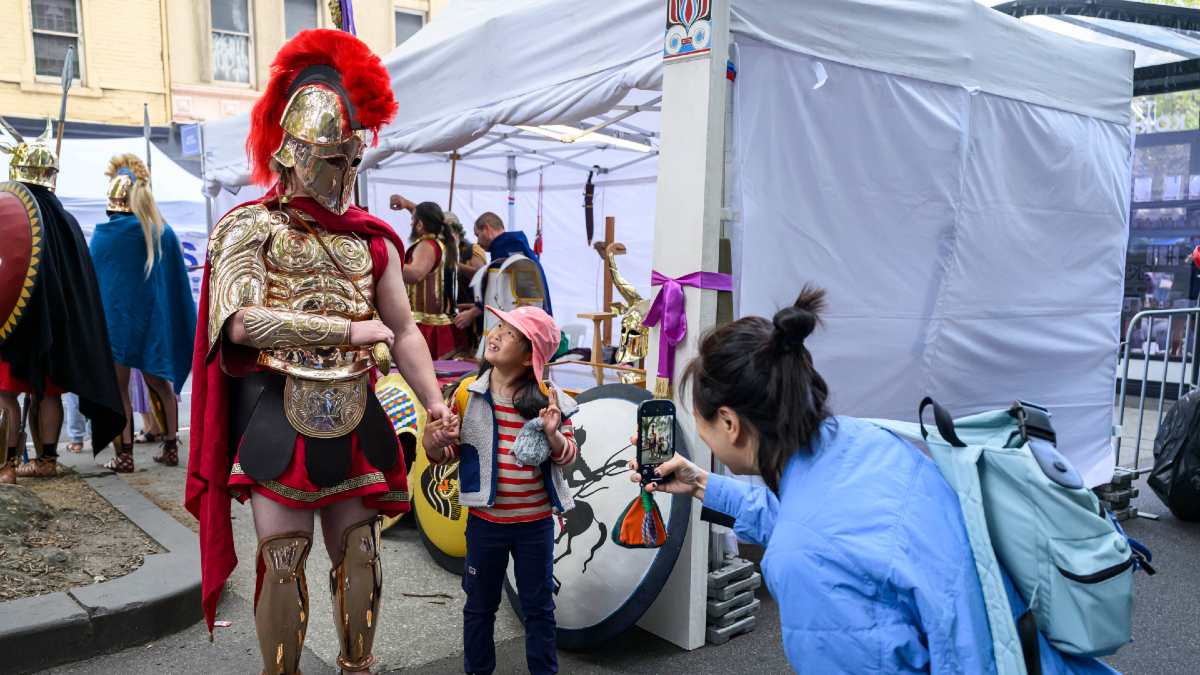 young girl getting photo taken with man dressed in historical costume at Antipodes Festival