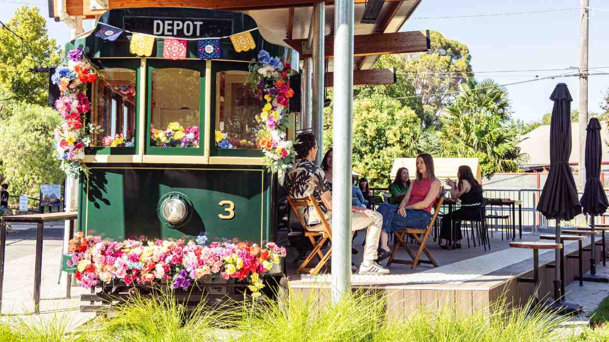 people sitting outside a decorative tram