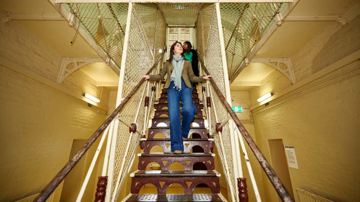 women descending a staircase in an old asylum