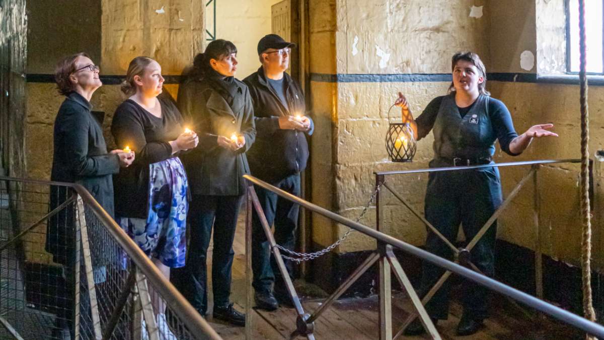 tour guide leading four guests on an old gaol tour